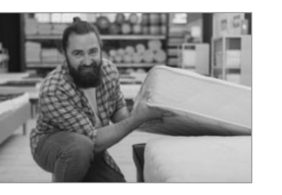 Personne portant un matelas, pour rappeler de choisir une bonne literie.