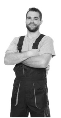 Éric, personne en tenue de travail, debout, bras croisés, souriant.