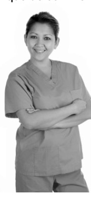 Sylvie, personne en tenue professionnelle, debout, bras croisés, souriante.